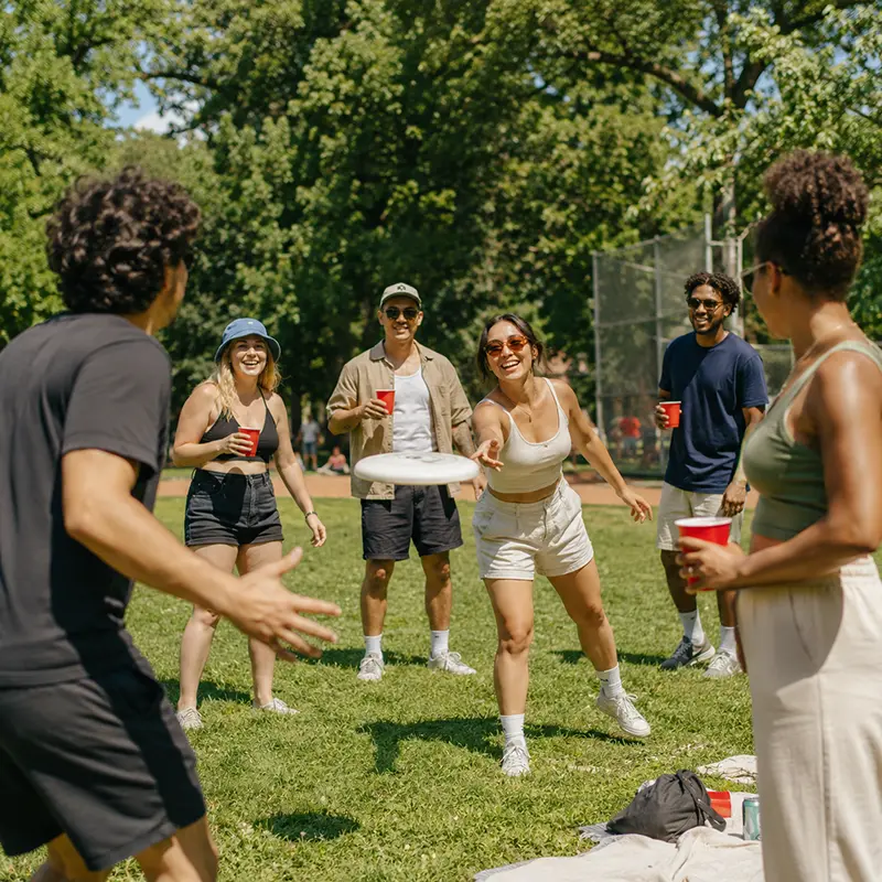 People playing frisbee in the park at a ramen crew social event